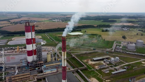 Aerial view of chemistry plant, flyind close to smoking industrial pipe with green background, chemical factory.  