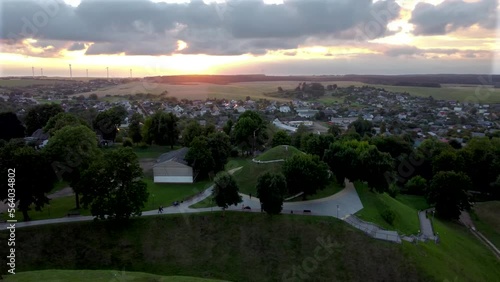 Aerial view of beutiful village on sunset, green meadows and thunderclouds, storm clouds