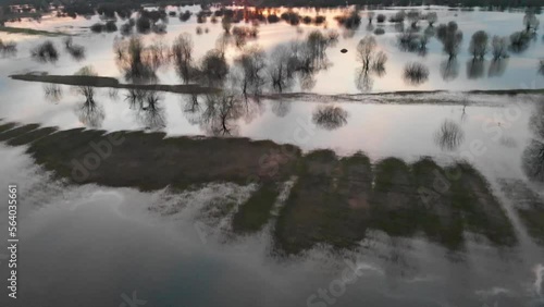 River water flooded fields and meadows and forest. Sunset view of river going out of it banks.  