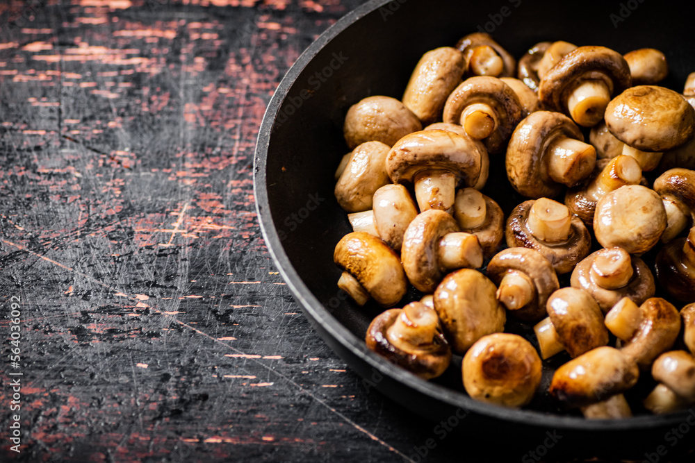Fried small mushrooms in a frying pan. Fried small mushrooms in a frying pan.