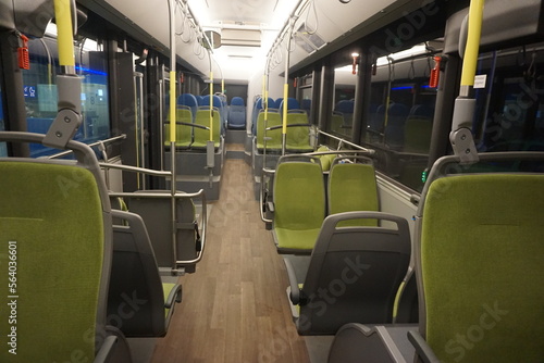 Innenausstattung mit grünen Sitzplätzen in ausgeleuchtetem Bus bei Nacht im Winter