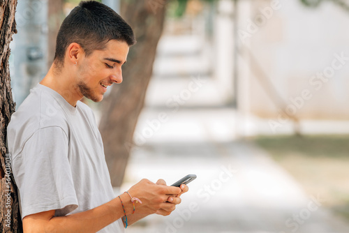young teenager with mobile phone in the street