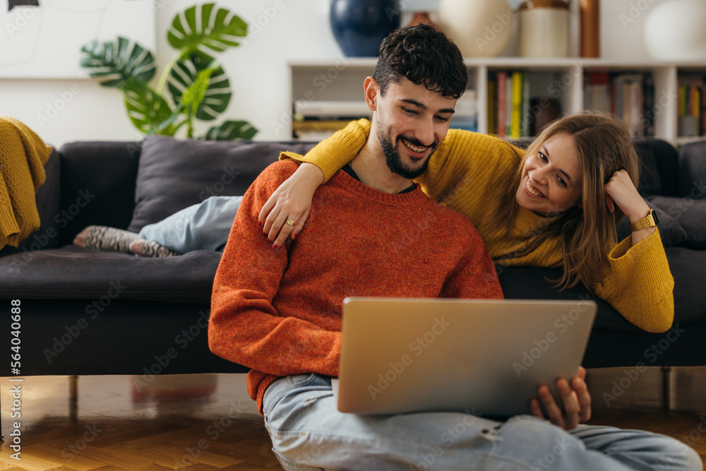 © cherryandbees - Young couple is looking at the laptop at home © cherryandbees - Young couple is looking at the laptop at home