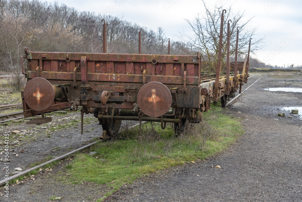 Old rusty industrial freight wagon in an abandoned train station. Train car claimed by nature. Old rusty industrial freight wagon in an abandoned train station. Train car claimed by nature.