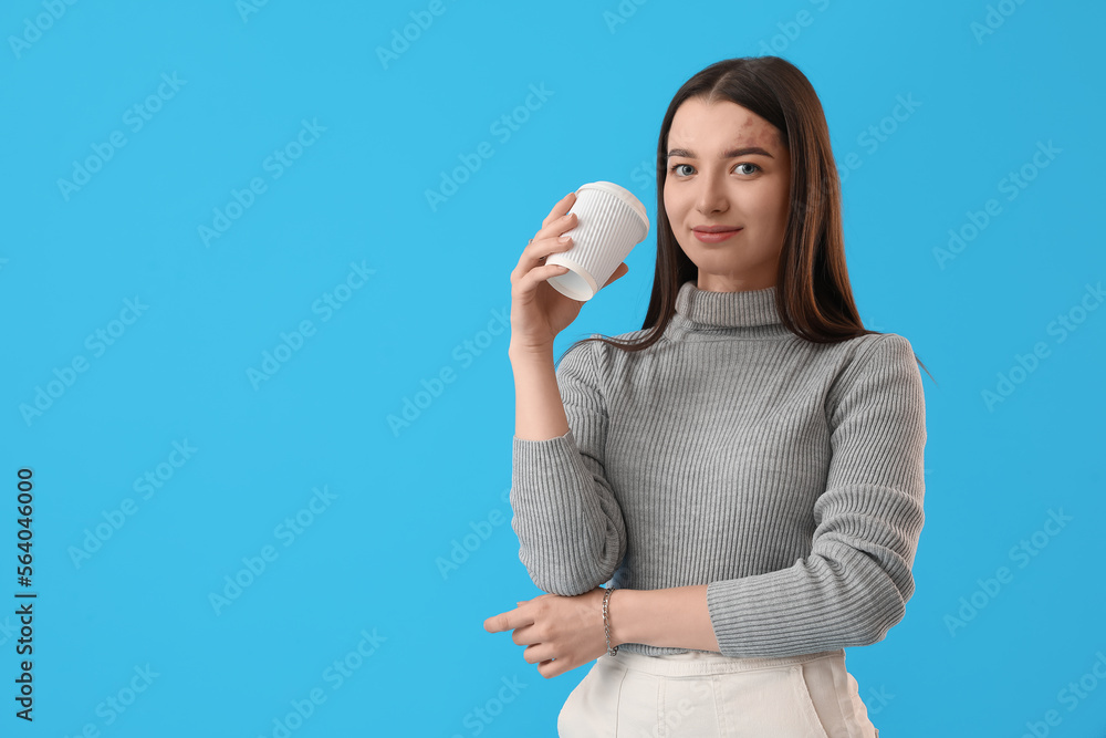 Young woman with takeaway cup of coffee on blue background
