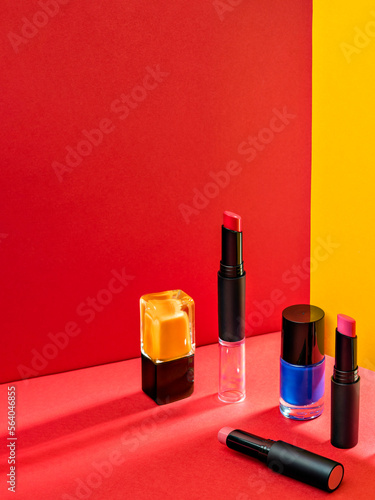 Composition with makeup products. Lipstick and nail polish. Cosmetic products advertisement on red background with Hard light. Product Advertising environment. Sale of beauty products concept. © shyrokova
