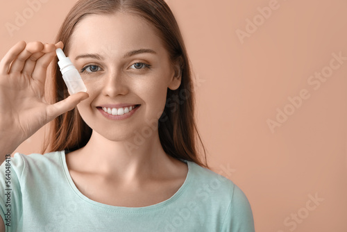 Young woman with eye drops ...