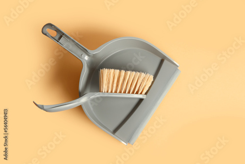 Plastic dustpan with brush on color background