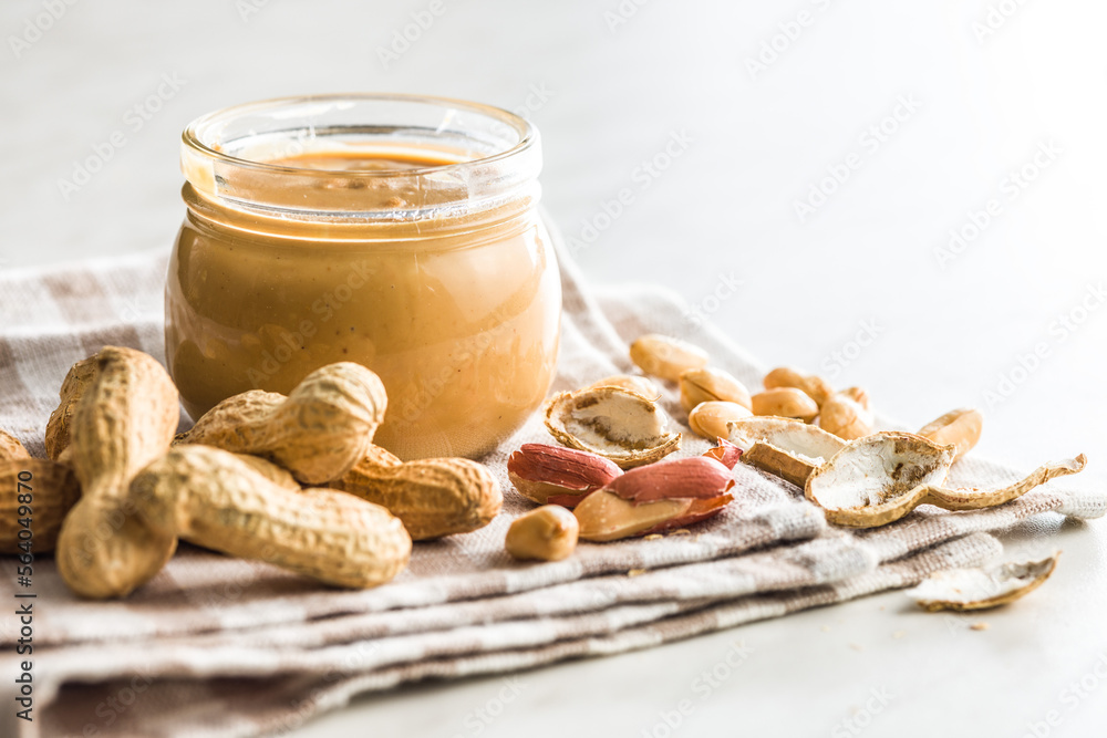 Peanut butter in jar on kitchen table. Peanut butter in jar on kitchen table.