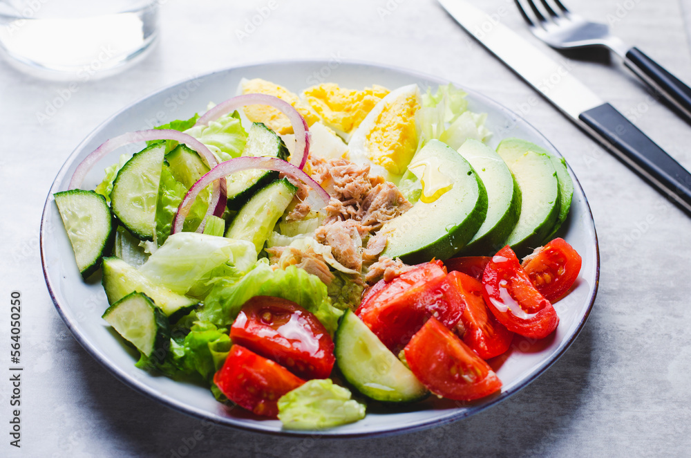 Tuna Salad, Healthy Food, Fresh Salad with Lettuce, Avocado, Cherries, Cucumber and Eggs on a Plate on Bright Background