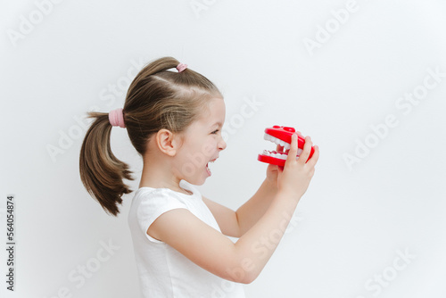 Cute happy caucasian toddler girl playing with dentist. Medical stomatology. Dental, oral care,healthcare concept. White background.