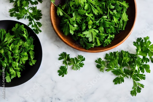 fresh parsley leaves in wooden bowl and black bowl on flat surface top view