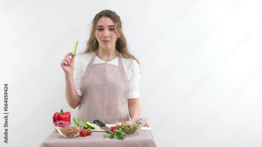 young beautiful girl cook woman nibbles fresh cucumber she shows thumb up class likes healthy food she shows index finger up choose this food there is space for text healthy food vegetable shop ad young beautiful girl cook woman nibbles fresh cucumber she shows thumb up class likes healthy food she shows index finger up choose this food there is space for text healthy food vegetable shop ad