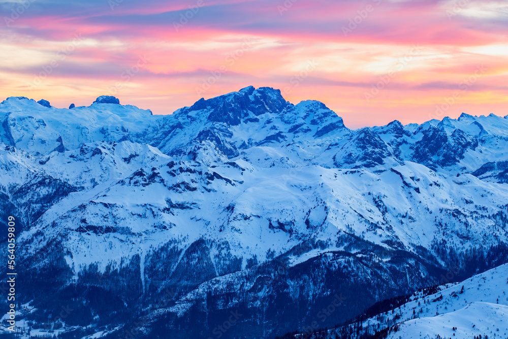 Red clouds over sharp winter mountain peaks in the dolomites