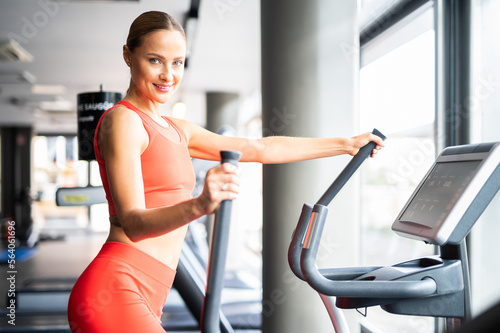 Woman exercising in a gym with an elliptical cross trainer