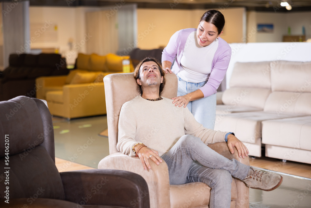 Couple spend their time in the furniture salon looking for a new armchair