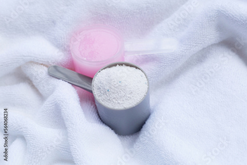 Fototapeta Naklejka Na Ścianę i Meble -  Detergent powder and fabric softener in measuring spoon on towel. Laundry concept.