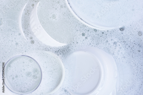 Dishes and bowls in water and bubbles of dishwashing liquid Fototapet