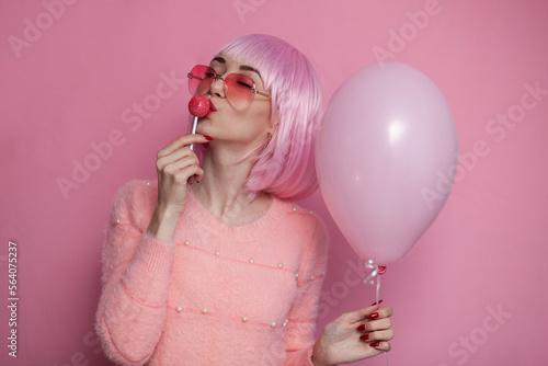 girl with pink short hair licks and sucks chupachups with pleasure, sexy concept photo