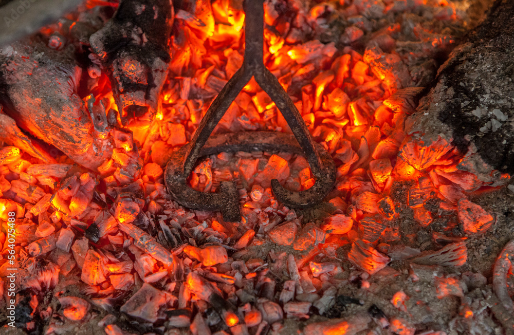 Branding iron for cattle over embers