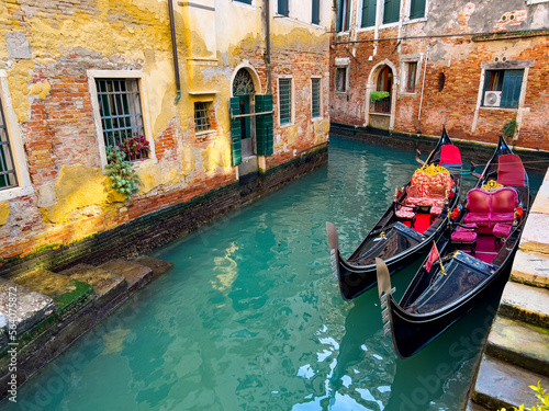 Canal with two gondolas in Venice, Italy. Venice postcard with Venice gondolas. Canals of Venice. Traditional Gondolas on narrow canal between colorful historic houses in Venice, Italy