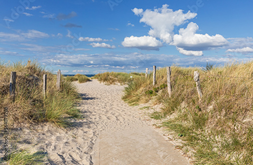 Weg mit Zäunen durch Dünen zum Strand an der Ostsee mit blauem Himmel mit Wolken bei Heiligenhafen, Schleswig-Holstein photo