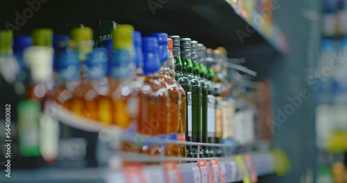 man choosing whiskey in store, taking bottle from shelf, closeup view of hand, 4K, Prores