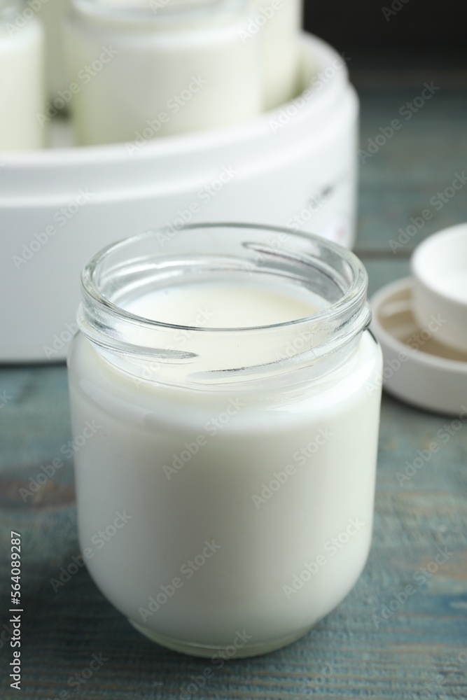 Glass jar with tasty yogurt on blue wooden table Glass jar with tasty yogurt on blue wooden table