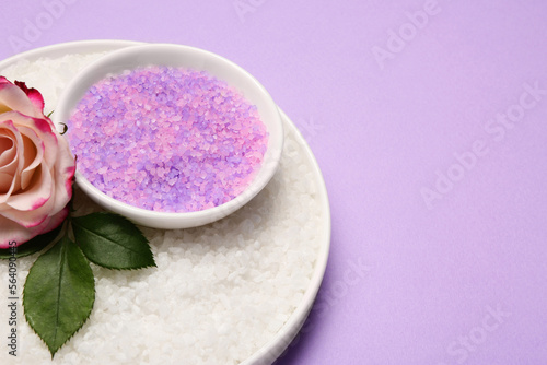Aromatic sea salt and beautiful flower on purple background. Space for text
