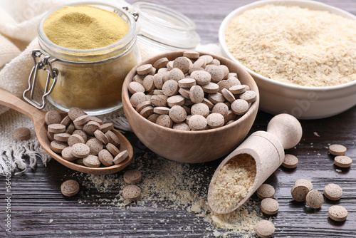 Different types of brewer`s yeast on wooden table photo