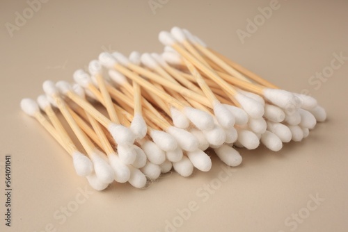 Many clean cotton buds on beige background, closeup