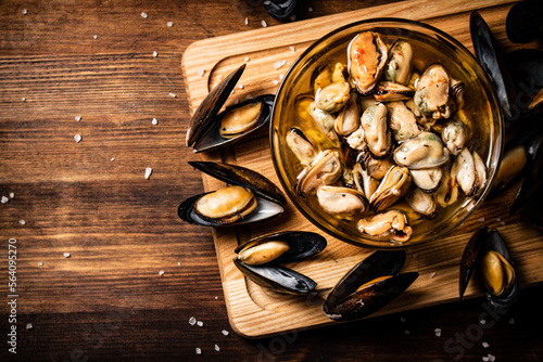 Delicious pickled mussels in a bowl on a cutting board. 