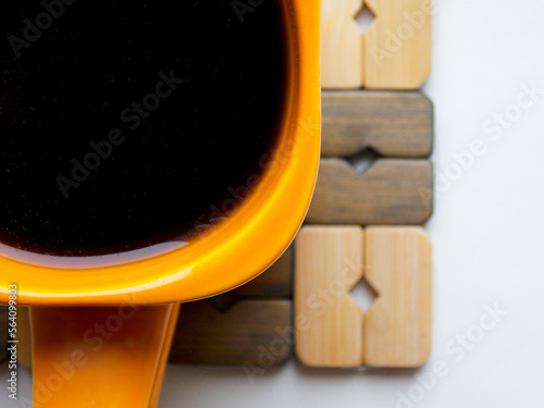 Orange coffee mug on a stand. Very close-up