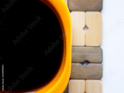 Orange coffee mug on a stand. Very close-up