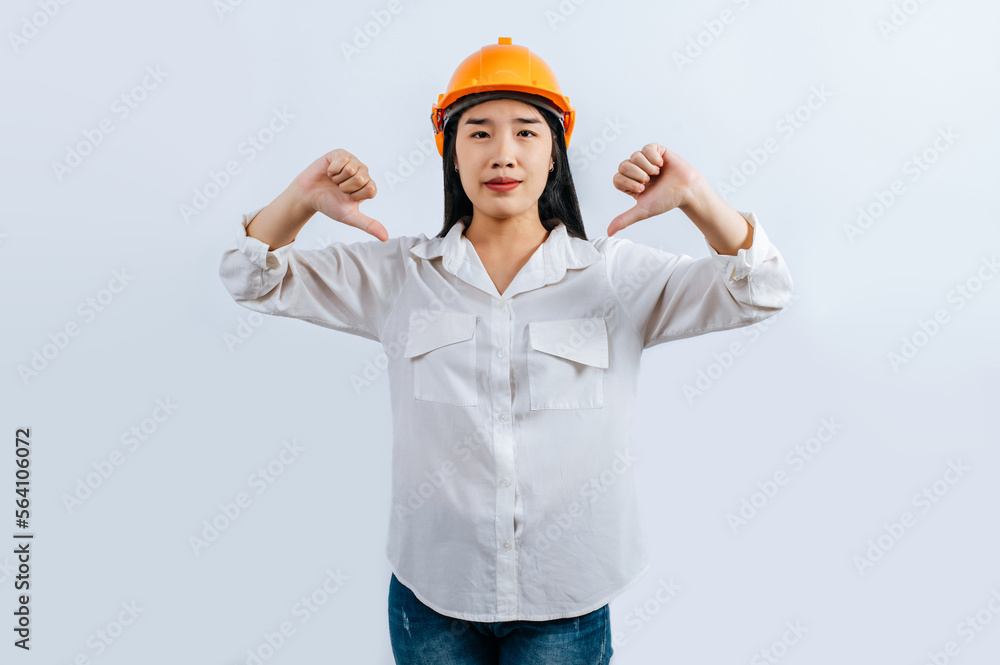 Young female engineer in helmet stand with thumb up posture Young female engineer in helmet stand with thumb up posture