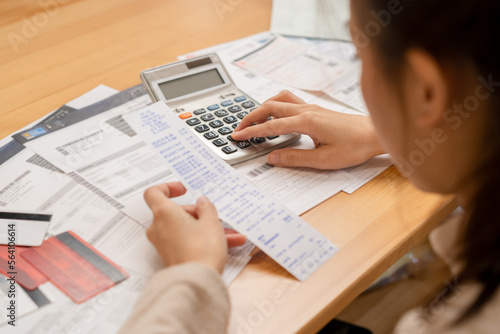 Financial owe asian young woman, girl suffer, stressed and confused, hand use calculator calculate expense from invoice or bill, have no money to pay, mortgage or loan. Debt, bankruptcy or bankruptcy.