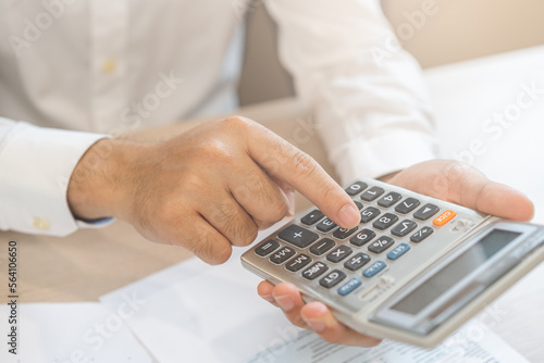 Deduction planning concept. Asian young man hand using calculator to calculating balance prepare planning filling 1040 tax form business individual income for pay money form personal tax reduction.