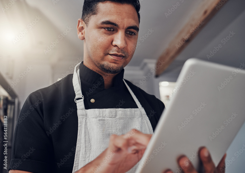 Man with apron, focus and tablet for online recipe, cooking instructions and connection in kitchen. Male, chef and gentleman with device, communication and search for ingredients, thinking and ideas - obrazy, fototapety, plakaty 