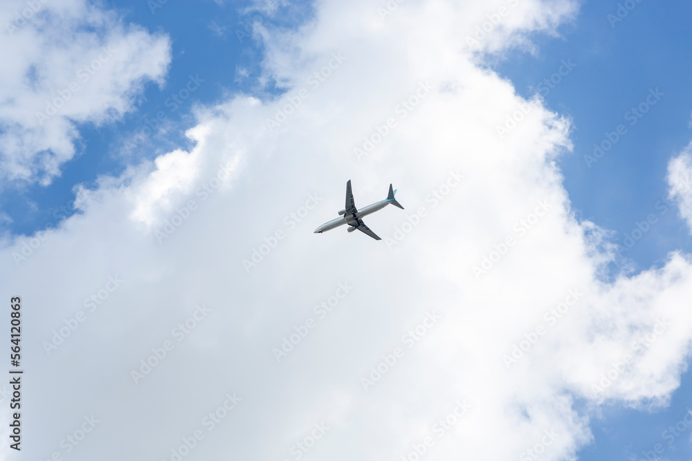 파란 하늘과 흰 구름을 배경으로 비행중인 비행기