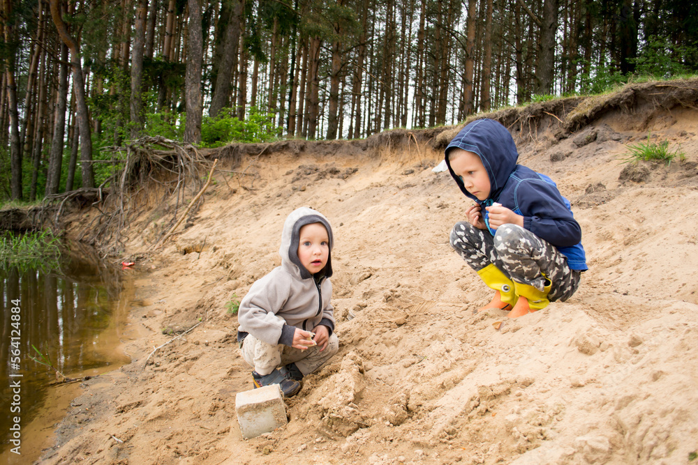 Children walk on the shore of the lake. Boys in nature. Children walk on the shore of the lake. Boys in nature.