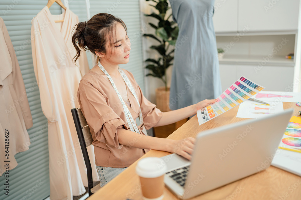 Fototapeta premium Asian Woman Fashion Designer Stylish Artist or creative designer drawing on sketch book with new project design