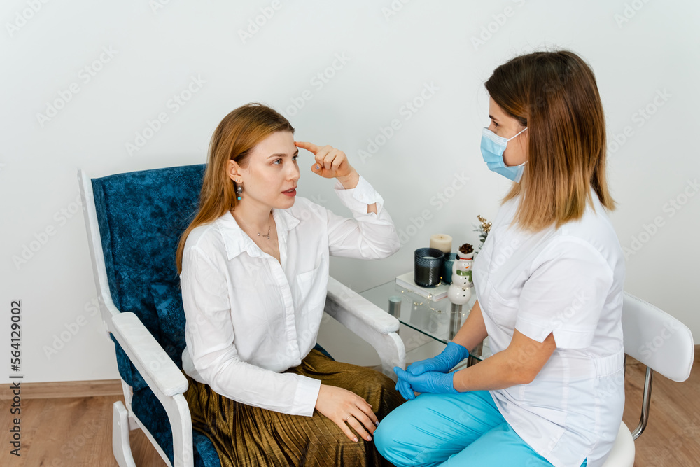 Girl tells what she wants change in her face. Female beauty doctor talking with patient. Independent woman in consultation with a doctor in modern medicine cabinet. Consultation in cosmetology clinic. Girl tells what she wants change in her face. Female beauty doctor talking with patient. Independent woman in consultation with a doctor in modern medicine cabinet. Consultation in cosmetology clinic.