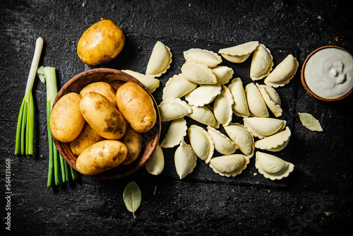 Potato dumplings on a stone board with sour cream and green onions. 