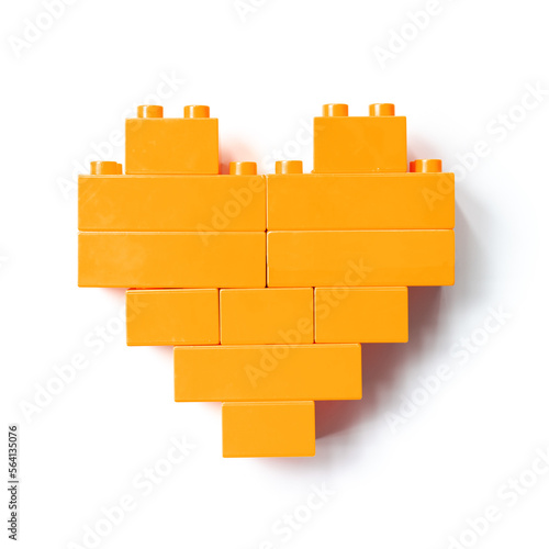 Orange heart from Bricks isolated on white background  top view cut out object  design element  shape heart from child Bricks construction. Love concept  Valentine card  Toys  games
