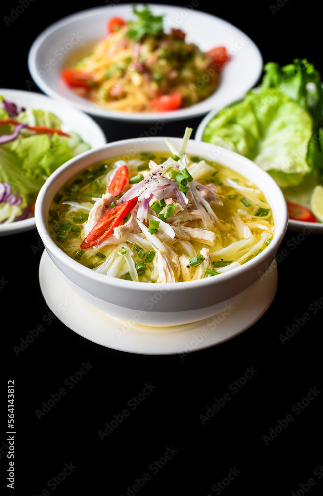Chicken soup Pho ga in vietnamese style on black background with banh mi bread, salad and pasta carbonara Chicken soup Pho ga in vietnamese style on black background with banh mi bread, salad and pasta carbonara