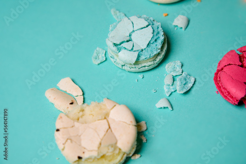 Close-up of macaroons of different colors in blue background. Culinary and tsuking concept. Tasti tsolurful matzaroons. Pastel color. food deconstruction.. photo