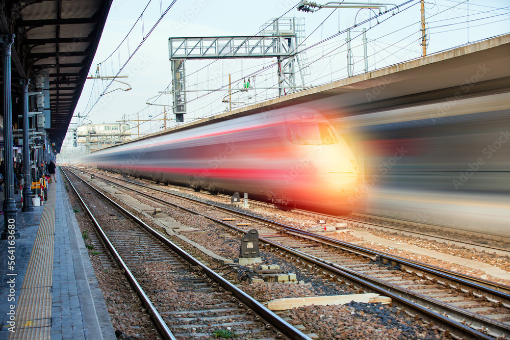 Blue high speed train runs on rail tracks - The train is going too fast as a result the air pressure is causing too much heat at the front Blue high speed train runs on rail tracks - The train is going too fast as a result the air pressure is causing too much heat at the front