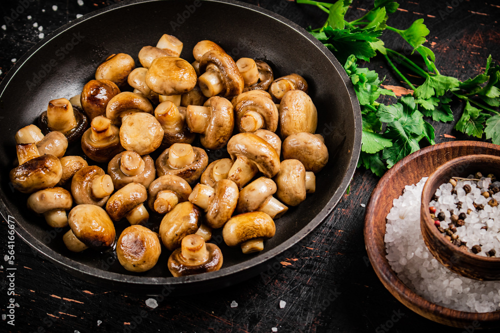 Frying pan with fried small mushrooms with parsley. Frying pan with fried small mushrooms with parsley.