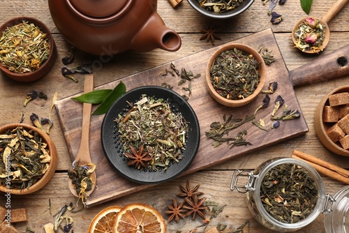 Flat lay composition with different dry teas on wooden table