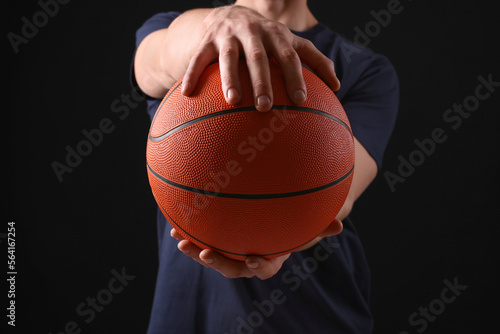 Athletic man with basketball ball on black background, closeup © New Africa